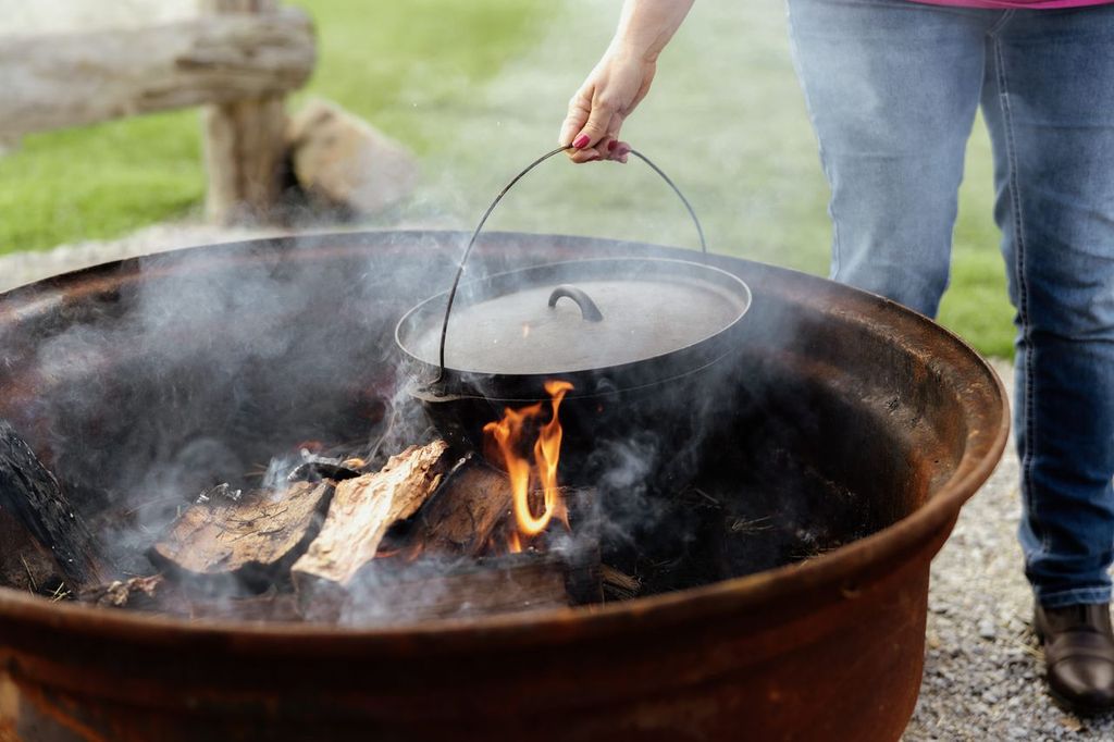 Person using a camp oven on a fire