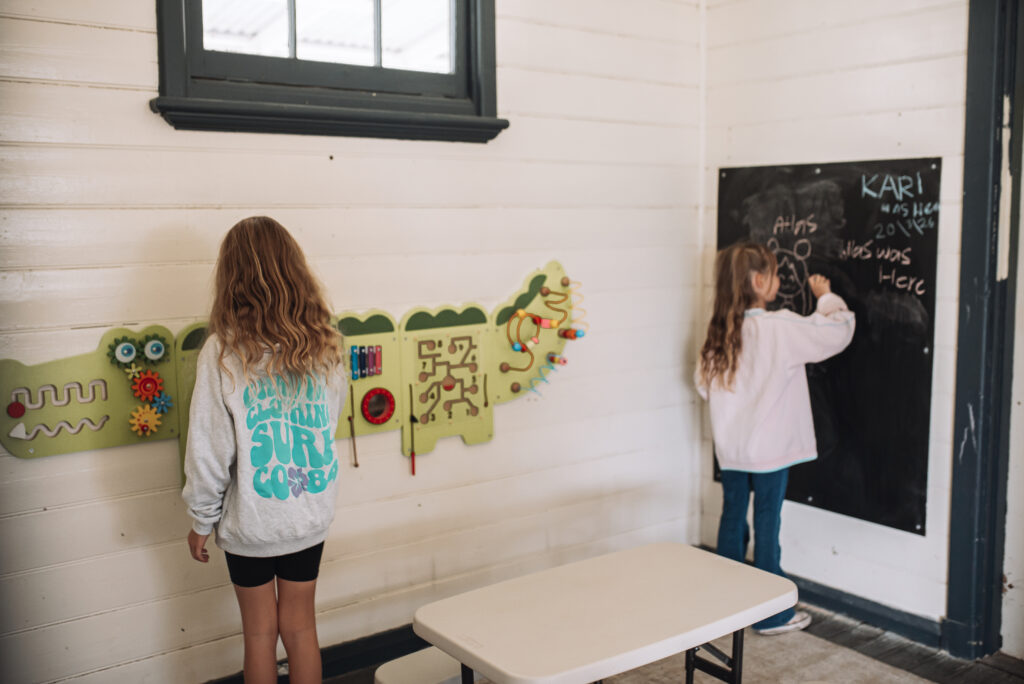 Children drawing on a chalk board and playing games in the recreational room at BIG4 Long Jetty Caravan Park